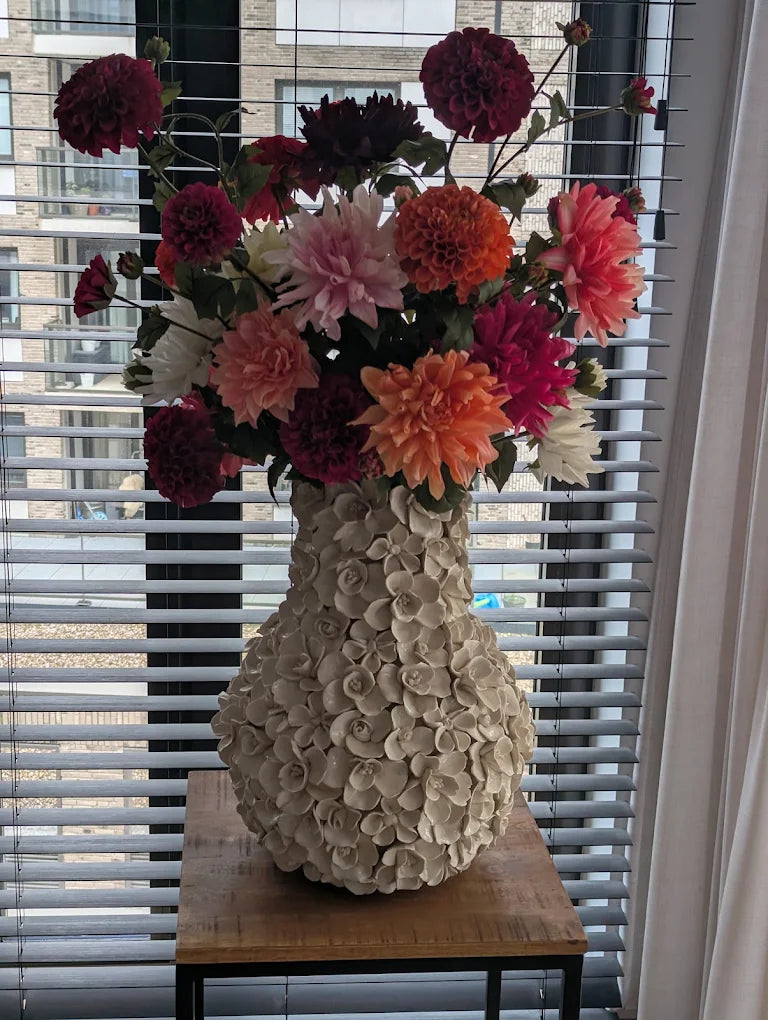 Kundenfoto maßgefertigter Seidenblumenstrauß mit Dahlien von Fleurisant in einer großen weißen Keramikvase mit Blumenverzierung